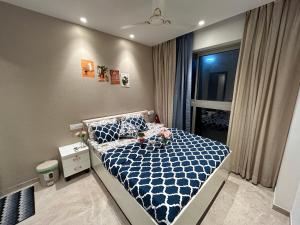 ein kleines Schlafzimmer mit einem blauen und weißen Bett in der Unterkunft 1BHK in Hiranandani Powai A in Mumbai