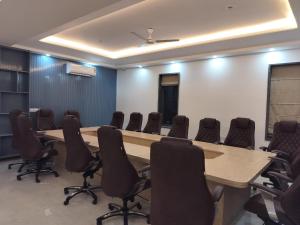 uma sala de conferências com uma mesa longa e cadeiras em Elite 32 Avenue - Near Google Building em Gurgaon