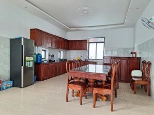 a kitchen with a table and chairs and a refrigerator at C2.53 Hoàng My Villa in Vung Tau