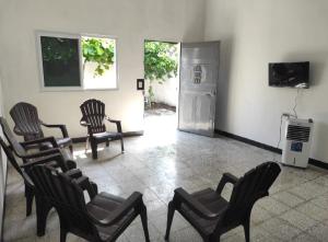 Habitación con sillas, nevera y TV. en Casa de descanso Grace, en Puerto San José