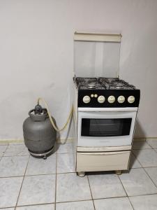 a stove in a kitchen with a pot next to it at Casa inteira in Solânea