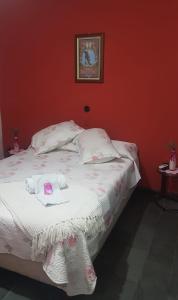 a bedroom with a white bed with red walls at Hotel Bella Unión in Bella Unión