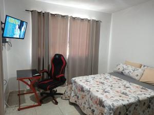 1 dormitorio con 1 cama, 1 silla y TV en 15 min de playa Casa minimalista, en Ciudad Madero