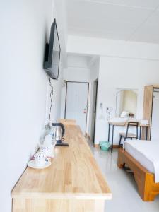 a living room with a wooden table and a television at Fang Villa Hotel in Fang