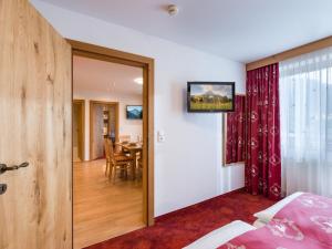 Schlafzimmer mit einer Tür, die zu einem Esszimmer führt in der Unterkunft Hotel Feichter in Söll