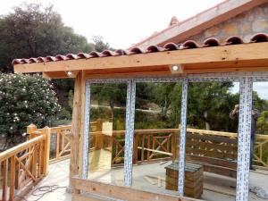 a wooden gazebo with glass doors on a deck at chalet el ghaba in Ben Metir