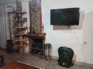 sala de estar con chimenea y TV de pantalla plana en chalet el ghaba en Ben Metir