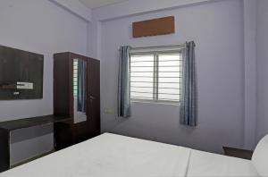 1 dormitorio con cama y ventana en Hotel Sambodhi Palace, en Bhopal