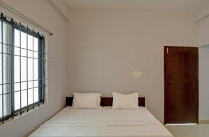 a bed in a room with a large window at Hotel Sambodhi Palace in Bhopal
