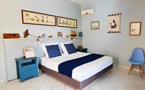 a bedroom with a bed and a blue chair at Ti case fleurie * Piscine * Jardin tropical in Saint-Leu