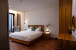 a bedroom with a white bed and a wooden floor at Luel Hotel in Jeonju