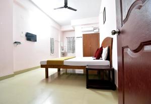 1 dormitorio con 1 cama y puerta de madera en Royal Green Accommodation Chennai Airport en Chennai