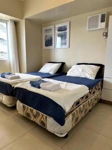 two beds sitting next to each other in a bedroom at Spacious 3 Bedroom Appartement @Avida Allgauers in Iloilo City