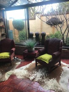 - un salon avec deux chaises et une fenêtre dans l'établissement Kyasaja Home away from home, à Pretoria