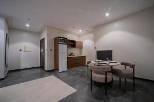 a kitchen with a table and chairs in a room at Jawhrat Al Sharq Serviced Apartments in Al Khobar
