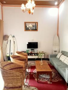 Krui的住宿－Walur Surf Villa，客厅配有沙发、椅子和桌子