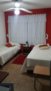- une chambre avec 2 lits et un ventilateur de plafond dans l'établissement Hotel Bella Unión, à Bella Unión