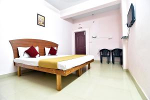 sypialnia z łóżkiem i telewizorem na ścianie w obiekcie ROYAL GREEN AIRPORT TRANSIT ACCOMMODATION w mieście Ćennaj