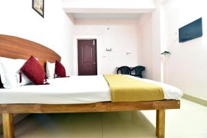 sypialnia z dużym łóżkiem z czerwonymi poduszkami w obiekcie ROYAL GREEN AIRPORT TRANSIT ACCOMMODATION w mieście Ćennaj