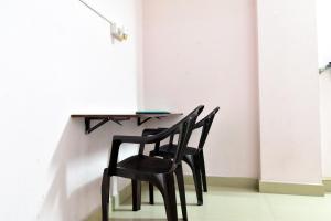 two black chairs sitting at a table in a room at ROYAL GREEN AIRPORT TRANSIT ACCOMMODATION in Chennai