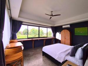 1 dormitorio con cama y ventana en Maple Ridge Ubud Villas, en Ubud