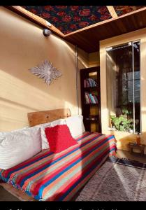 a bedroom with a bed with a colorful blanket at Casinha Limão Escondido in Sapucaí-Mirim
