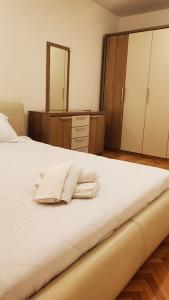 een slaapkamer met een bed met witte handdoeken bij Apartman Mila in Usje