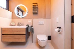 La salle de bains est pourvue de toilettes, d'un lavabo et d'un miroir. dans l'établissement Fichtenlodge Stubaital, à Neustift im Stubaital