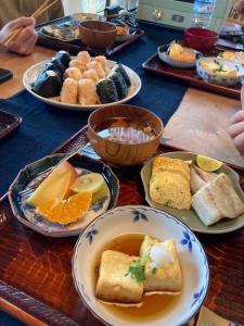 einen Tisch mit Teller mit Lebensmitteln auf einem Tisch in der Unterkunft 小舞庵 Komaian in Tokushima