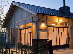 uma pequena casa com grandes portas de vidro e uma solarpertureperture em 小舞庵 Komaian em Tokushima