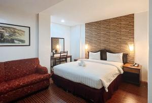 a hotel room with a bed and a chair at RedDoorz at Diamond Spring Hotel Angeles City in Angeles