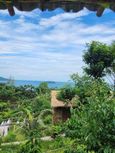 a thatch hut with the ocean in the background at Sweet Jungle Glamping in Koh Rong Island