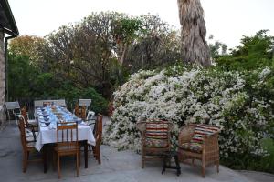 uma mesa de jantar e cadeiras com flores brancas em HH 820 Accomodation em Grootfontein