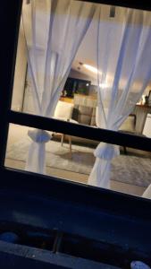 a window with white curtains in a living room at Jolie maison de campagne - Morisel in Morisel
