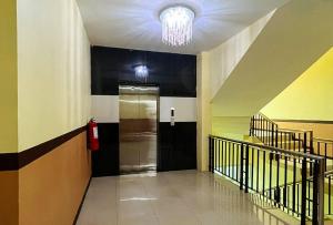 um corredor com uma porta preta e um lustre em RedDoorz at Diamond Spring Hotel Angeles City em Angeles