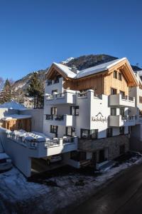 a white building with a boat in front of it at Haus Küchelspitz in Ischgl