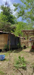 una casa con techo y estructura de madera en Rent a Tent, en Maluk