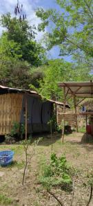 una casa con techo y estructura de madera en Jungle Glamping Tent Two, en Maluk