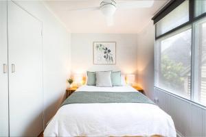 a bedroom with a bed and a large window at Orton Waves- Beach Life Awaits in Ocean Grove