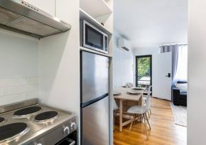 a kitchen with a stainless steel refrigerator and a table at Orton Waves- Beach Life Awaits in Ocean Grove