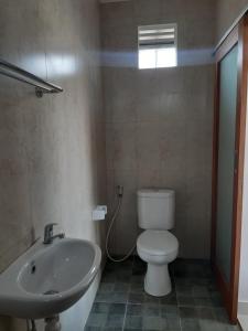 La salle de bains est pourvue de toilettes et d'un lavabo. dans l'établissement Patra House, à Ubud