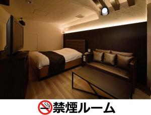 a room with a bed and a couch and a tv at Hotel LALA - Kitashiga - (Adult Only) in Nagoya