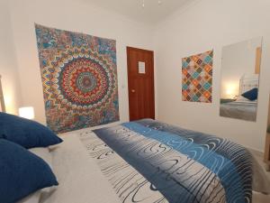 1 dormitorio con 1 cama con una pintura en la pared en CASA APARTAMENTO TERRAZAS DE ALGODONALES, en Algodonales