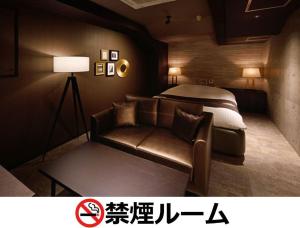 a hotel room with a bed and a couch at Hotel LALA - Kitashiga - (Adult Only) in Nagoya