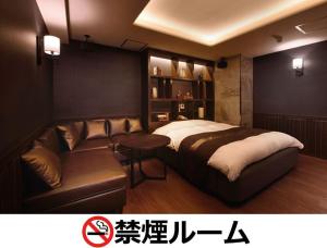 een slaapkamer met een bed en een bank bij Hotel LALA - Kitashiga - (Adult Only) in Nagoya