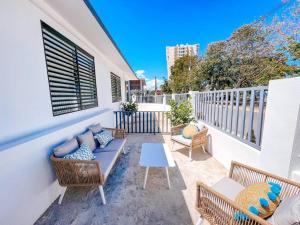 eine Terrasse mit einem Sofa und Stühlen auf dem Balkon in der Unterkunft Stylish Comfy Boho Style Home W/ Parking@ San Juan in San Juan