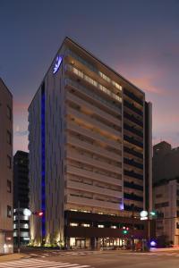 - un grand bâtiment avec un panneau nissan dans l'établissement Doutonbori Crystal Exe, à Osaka