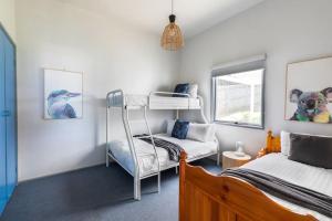 1 dormitorio con litera, 1 cama y ventana en Marlin House Ocean Getaway, en Ocean Grove