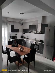 a kitchen with a wooden table and black chairs at Phily's in Volos +57 photos