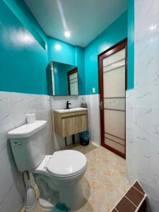 y baño con aseo blanco y lavamanos. en Ngermid Oasis - Studio W/ Kitchenette & Pool View en Koror